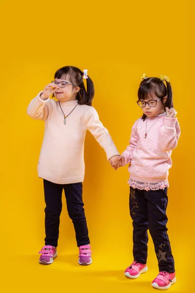 Contented unusual sisters with genetic disorder connecting their hands — Stock Photo, Image