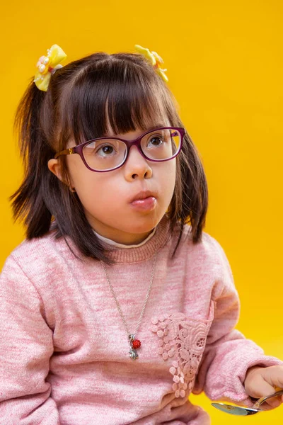 Attentive little girl with brown eyes having down syndrome — Stock Photo, Image