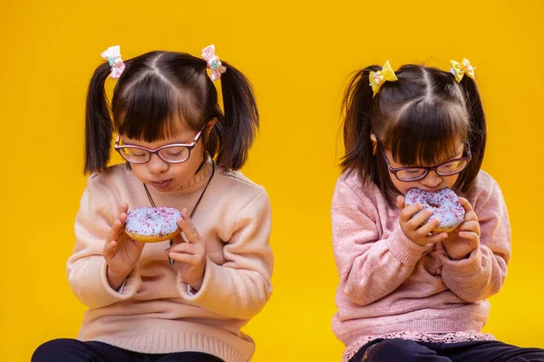 Wearing Pink Sweater Focused Young Sisters Disorder Enjoying Colored Donuts — Stock Photo, Image