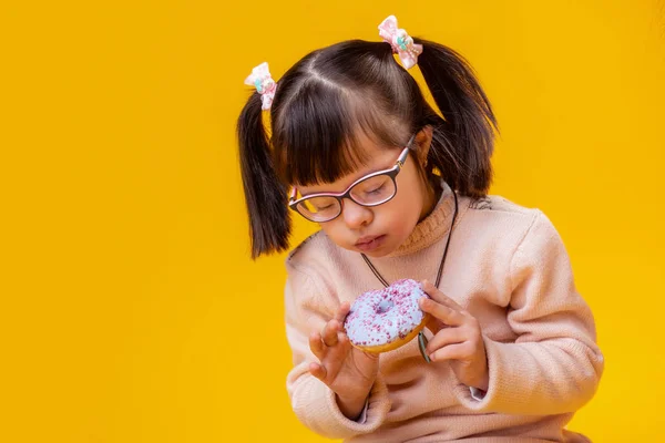 Concentrated young lady with mental disorder biting blue donut — Stock Photo, Image