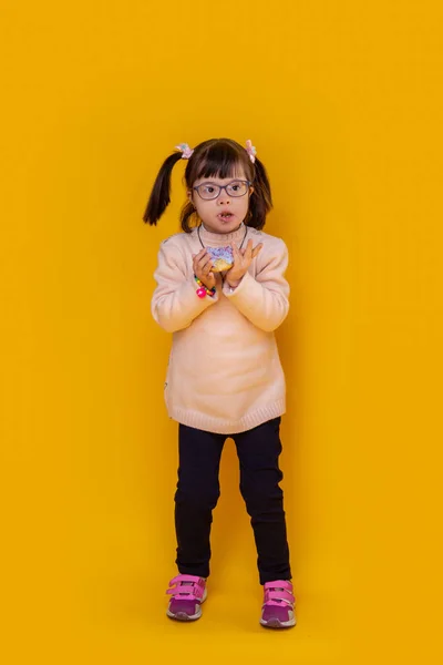 Apelando a un niño pequeño con trastorno mental que permanece contra el fondo amarillo —  Fotos de Stock