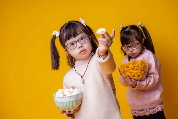 Unusual appealing child showing her food while sister standing behind — Stock Photo, Image