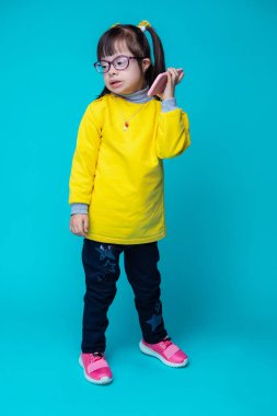 Sürpriz esmer kız. Kısa saçlı sevimli çocuk renkli kıyafeti giymiş süre Smartphone tek elle taşıma