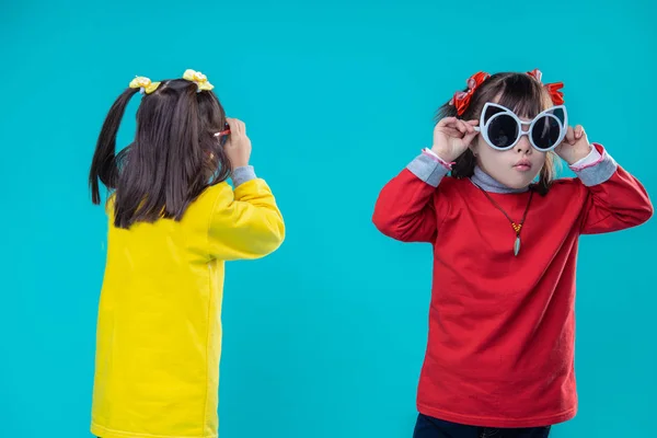 Interested short-haired girls with mental disorder trying on giant sunglasses — Stock Photo, Image