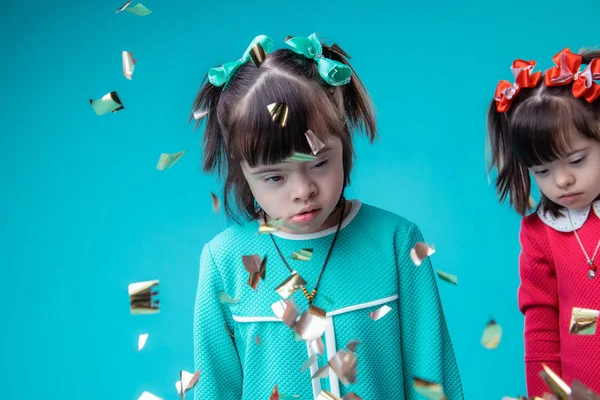 Dark-haired unusual girls with face features standing while confetti falling — Stock Photo, Image