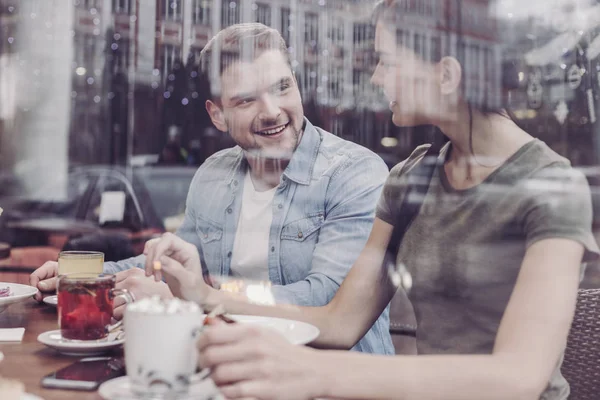 Iloinen nuori mies puhuu tyttöystävänsä kanssa — kuvapankkivalokuva