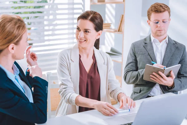 Blij mooie vrouw die lacht naar haar collega — Stockfoto