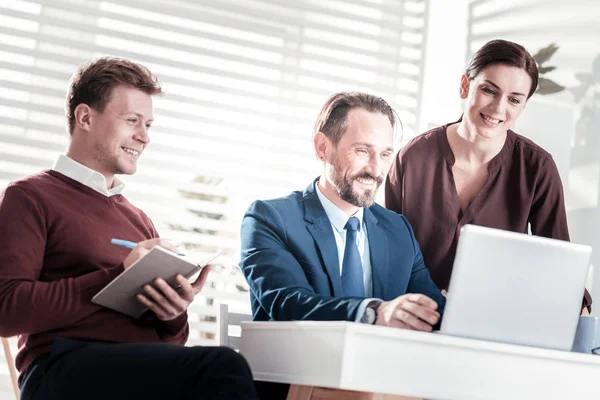 Joyful tre kollegor lyssnar på boss — Stockfoto