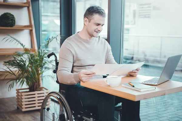 Concentrated disabled man reading papers — Stock Photo, Image