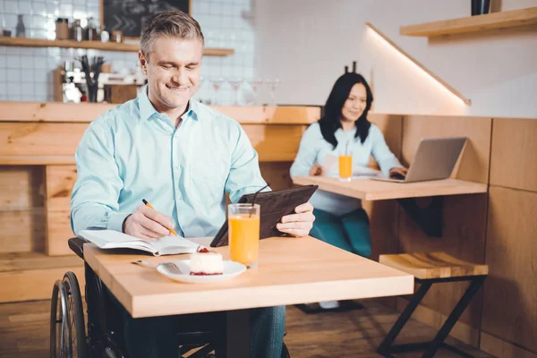 Smiling manager making notes in a notebook — Stock Photo, Image