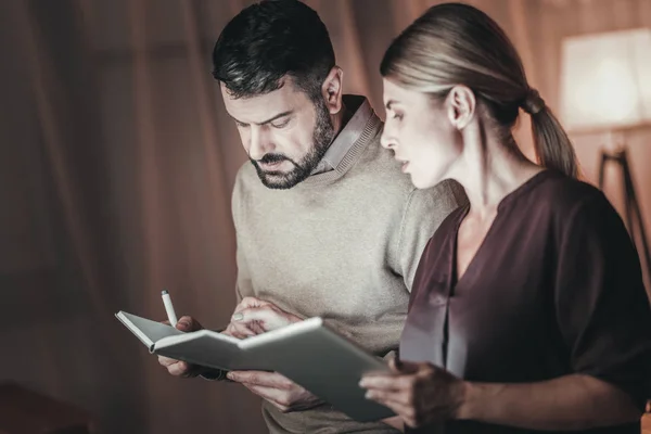 Concentrated two colleagues comparing notes — Stock Photo, Image