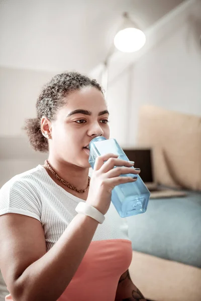 Afrikanisch-amerikanische nachdenkliche Frau trinkt klares Wasser — Stockfoto