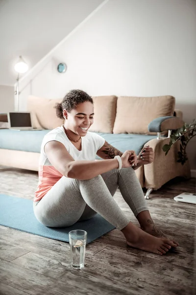 Mujer sonriente alegre sentada con las piernas desnudas — Foto de Stock