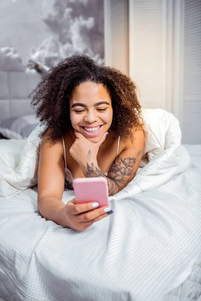 Улыбающаяся привлекательная женщина с отличным утром, лежа в постели — стоковое фото