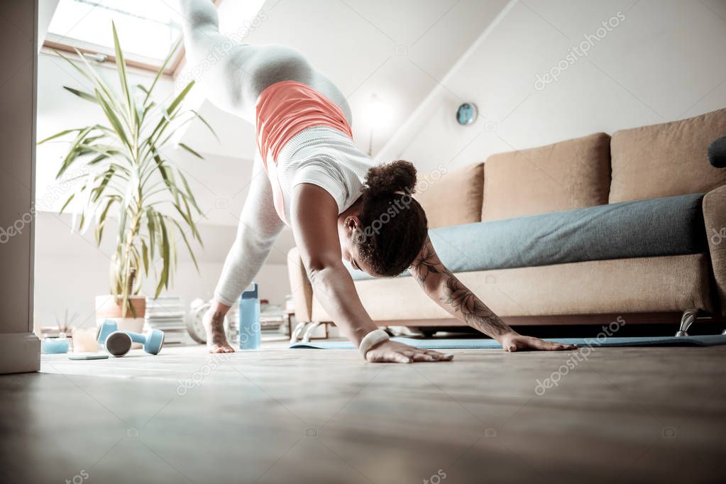 Woman rising legs. Attentive woman staying in professional yoga posture while being sportive and healthy