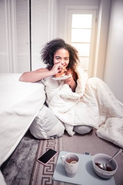 Taze kruvasan yemek. Fransız yatak odasında yumuşak ekmek ısırma sırasında kahvaltı cilveli güzel kadın