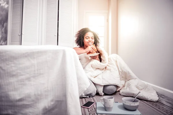 Souriant fille aux cheveux courts assis sur le sol de sa chambre — Photo