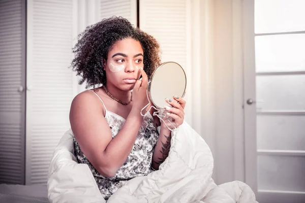 Allvarlig afrikanska amerikanska damen sätta fläckar under ögonen — Stockfoto