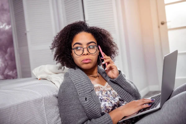 Allvarlig ung kvinna som bär tydliga glasögon under arbete med laptop — Stockfoto