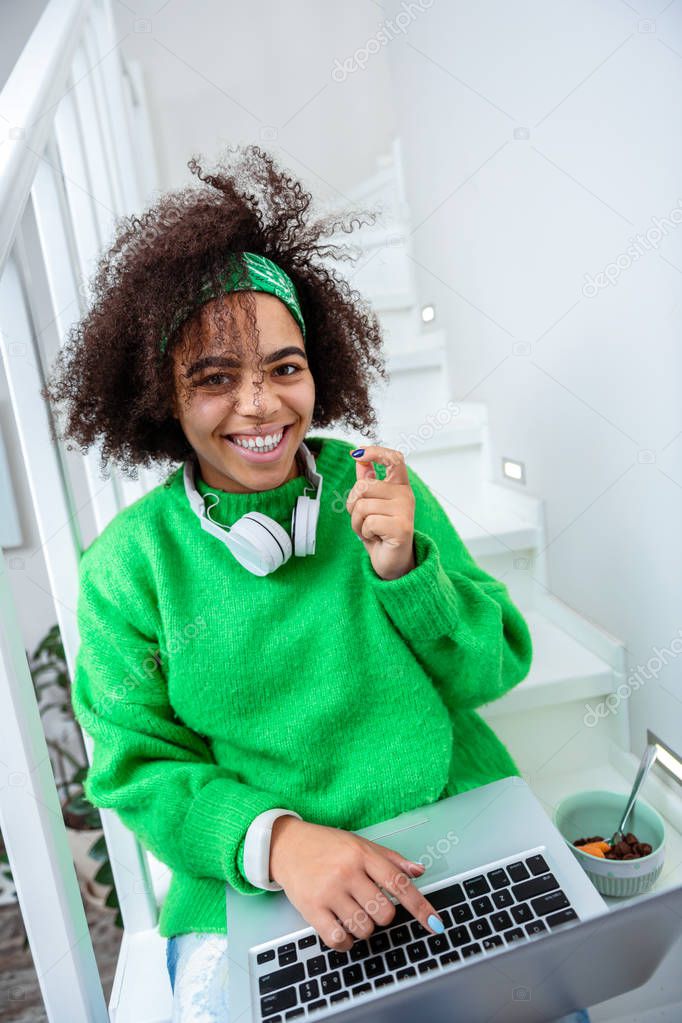 Smiling cheerful girl wearing bright cloths while relaxing at home