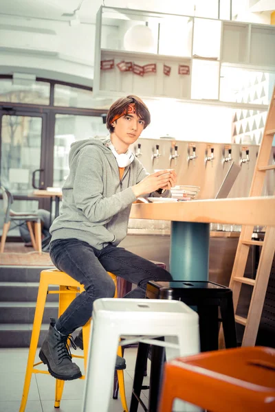 Έφηβος κάθεται στο καφενείο με ένα φλιτζάνι καφέ — Φωτογραφία Αρχείου