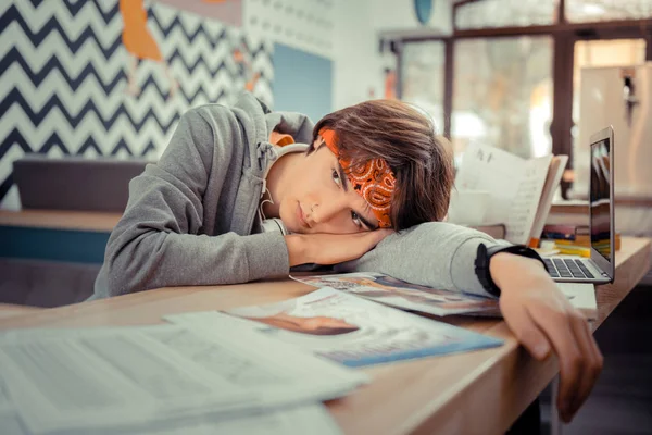 Estudante muito cansado deitado na mesa — Fotografia de Stock