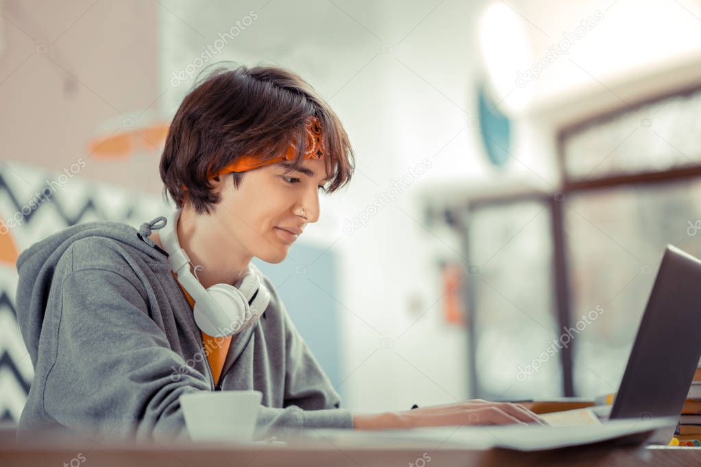 Remote job. The teenager working with the computer while sitting in the cafe