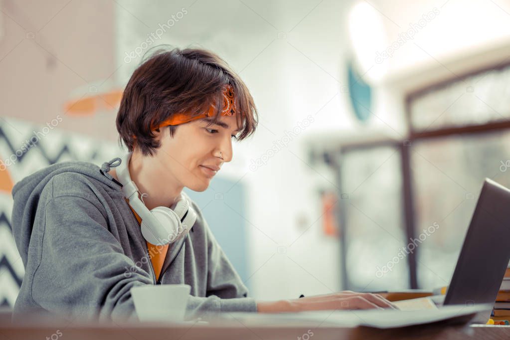 Teenager working with the computer while sitting in the cafe