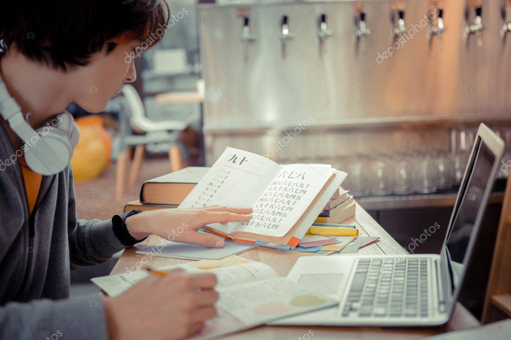 Eastern languages. The teenager concentratedly studying interesting and sophisticated eastern languages