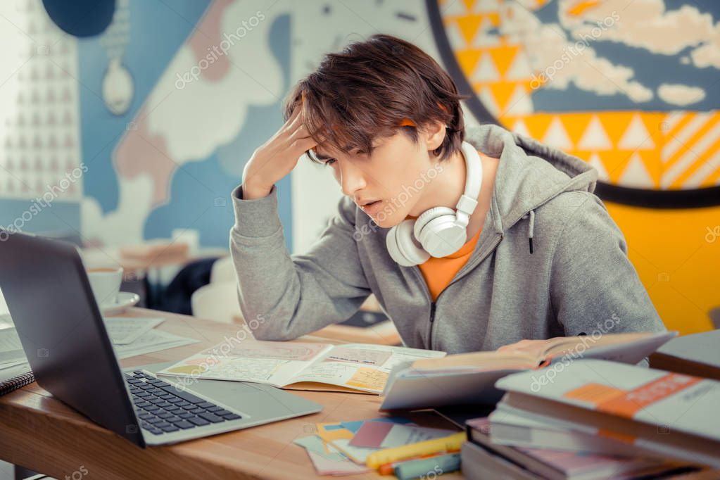 Concentrated on study. The student concentratedly preparing for the final test