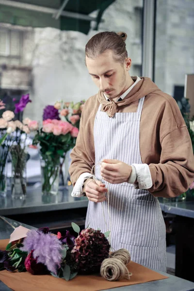 Serious young designer working with flowers in studio — Stock Photo, Image