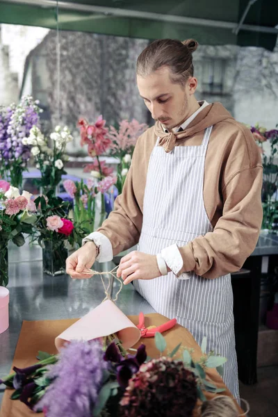 Konzentrierte stilvolle Floristin verpackt extrem modernes Bouquet — Stockfoto