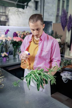 Yeşil bitki sulama sarışın erkek kişi konsantre