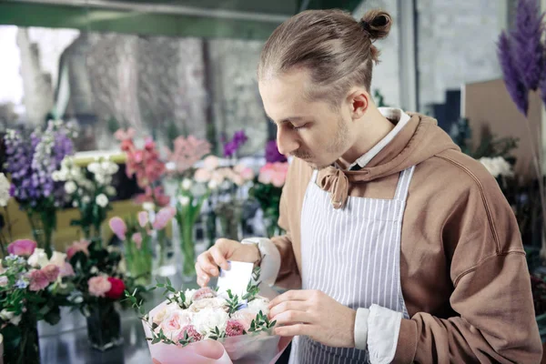 Konzentrierte junge Blumendesignerin fertigt Hochzeitskomposition — Stockfoto