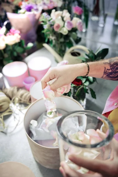 Foto focalizzata sulla mano maschile che lanciando petali — Foto Stock