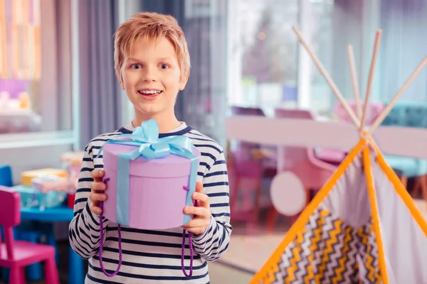 Добрый подросток демонстрирует коробку с подарком от родителей — стоковое фото