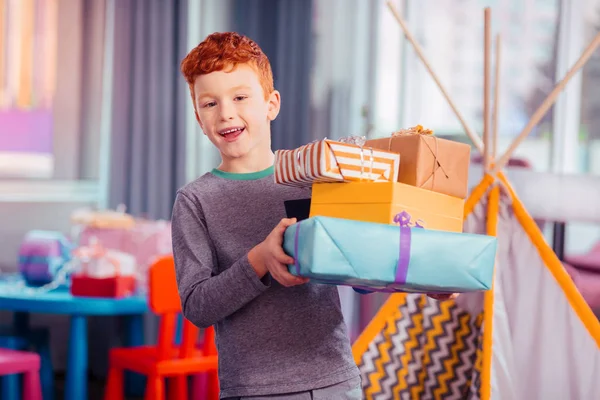 Vrolijke jongen aan te tonen zijn kleurrijke geschenkdozen — Stockfoto