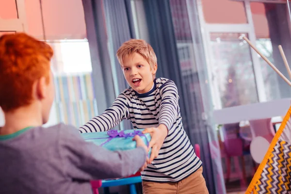 Emotional blonde boy taking box with present — Stock Photo, Image