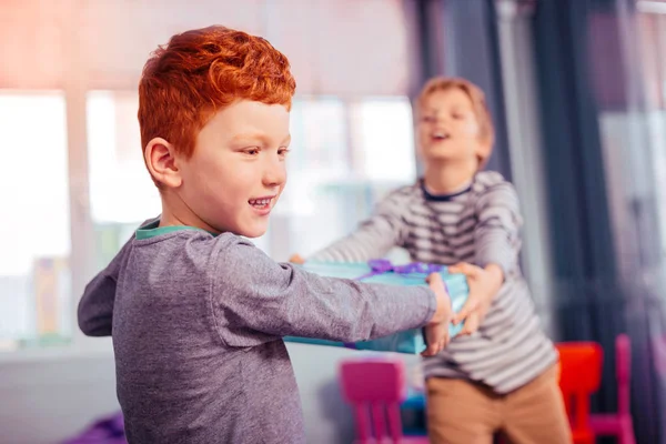 Serious red-haired kid standing on the foreground — Stock Photo, Image