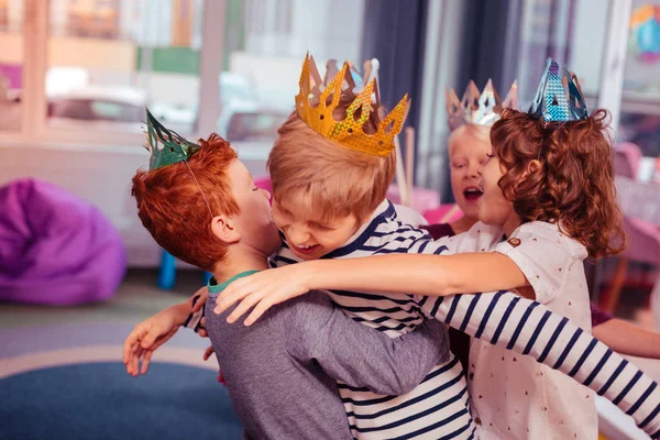 Šťastné děti nosí papírové korunky během party — Stock fotografie