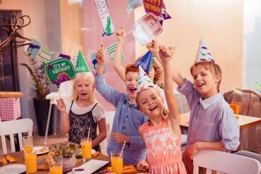 Fotoğraf kartları gösteren pozitif çok mutlu çocuklar