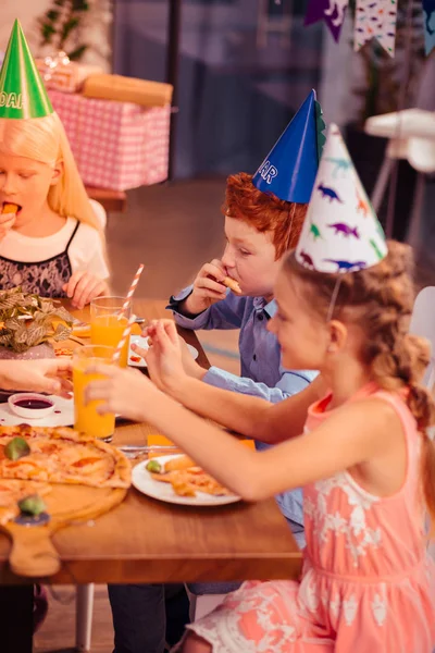Очарованные маленькие гости наслаждаются вкусной праздничной едой — стоковое фото