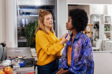 Sarışın stilist makyaj oldukça koyu renkli modeline