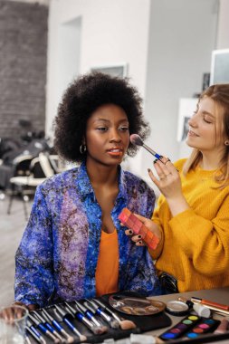 Makyaj koyu renkli modeline sarışın olumlu stilist