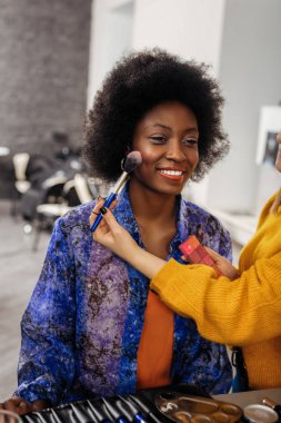 Çok gülen kara gözlü modeli kıvırcık saçlı hoş gülümseyen