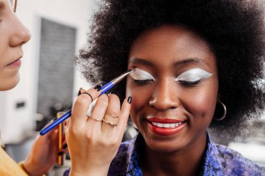 İş yerinde meşgul. Koyu renkli Afro-Amerikan model parlak kaptırdın bir moda stüdyoda otururken yoğun duygu ile