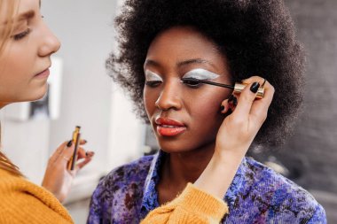 Siyah oje maskara kirpik üzerinde koyarak sarışın genç stilist