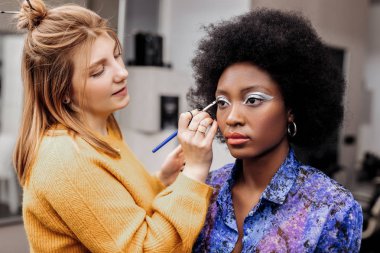 Yaratıcı seyir siyah oje ile sarışın genç stilist