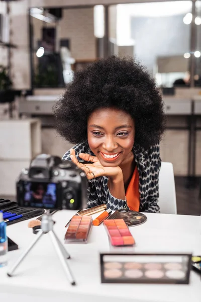 S úsměvem afroamerické ženy v oranžový top demonstrovat nový make-up — Stock fotografie
