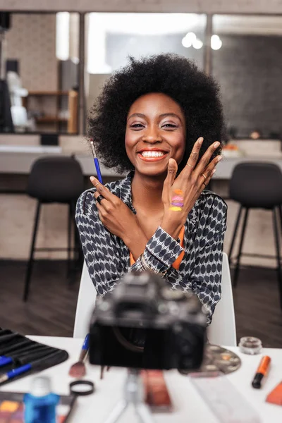 Dark-skinned african american woman demonstrating new bright swatches